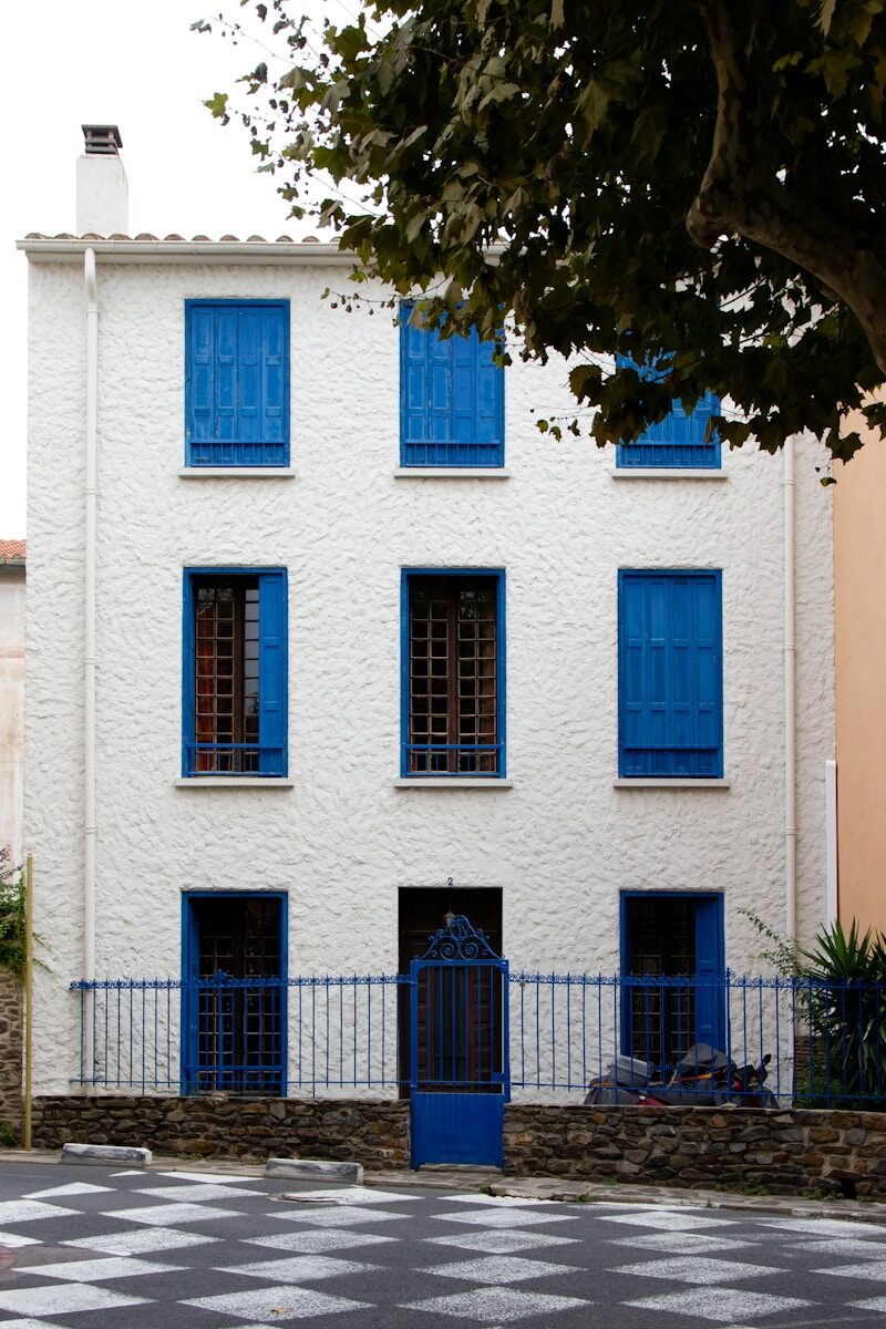 White Mediterranean house facade with blue shutters